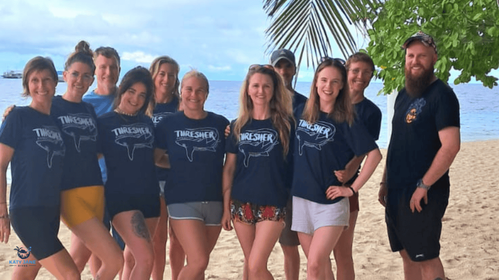 group of people on beach in matching shirts looking happy
